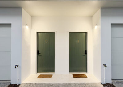 Freshly painted unit entry in Cairns with crisp white walls and green doors